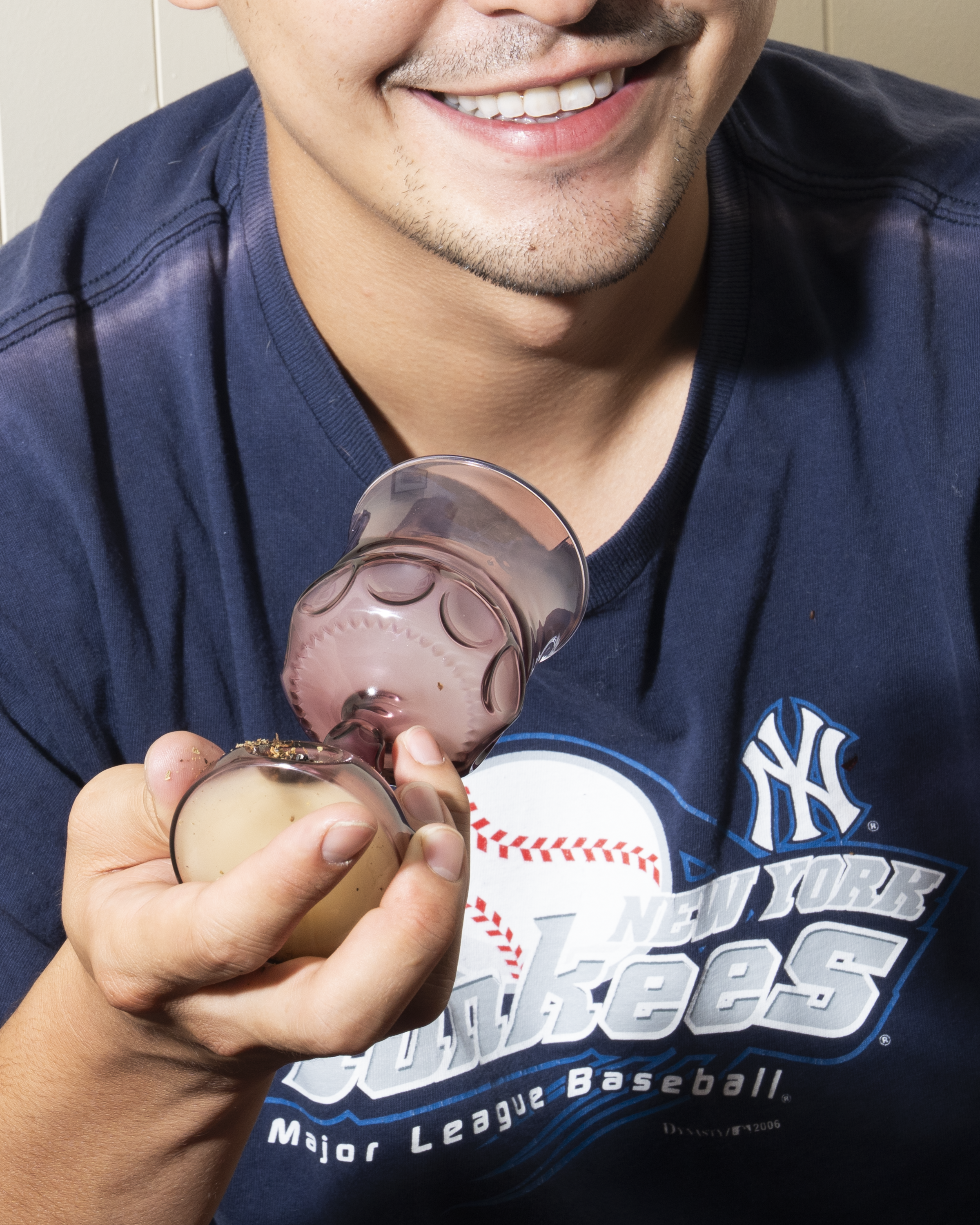 Person wearing a New York Yankees shirt holding a kiddush cup pipe