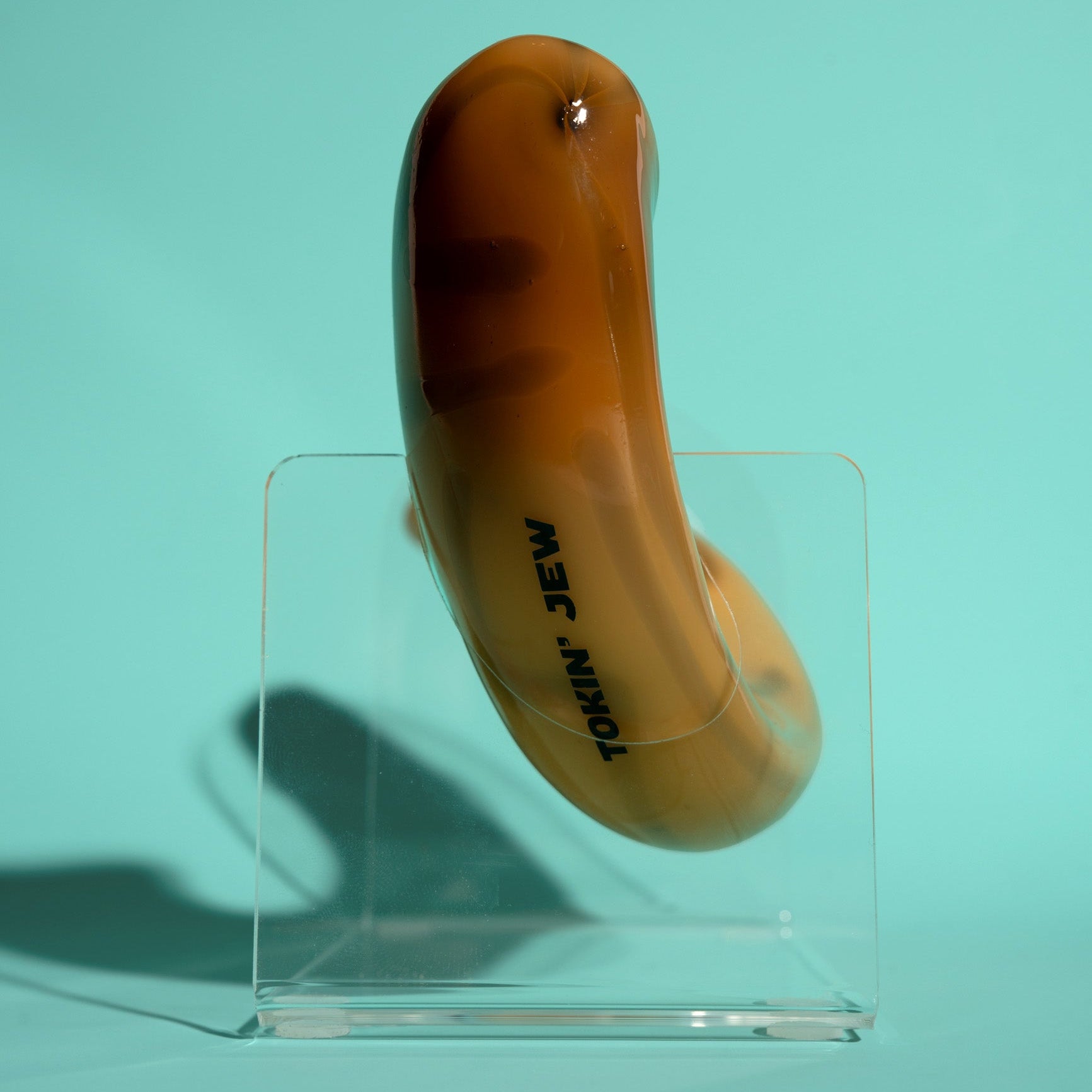 Shofar on a clear stand against a teal background