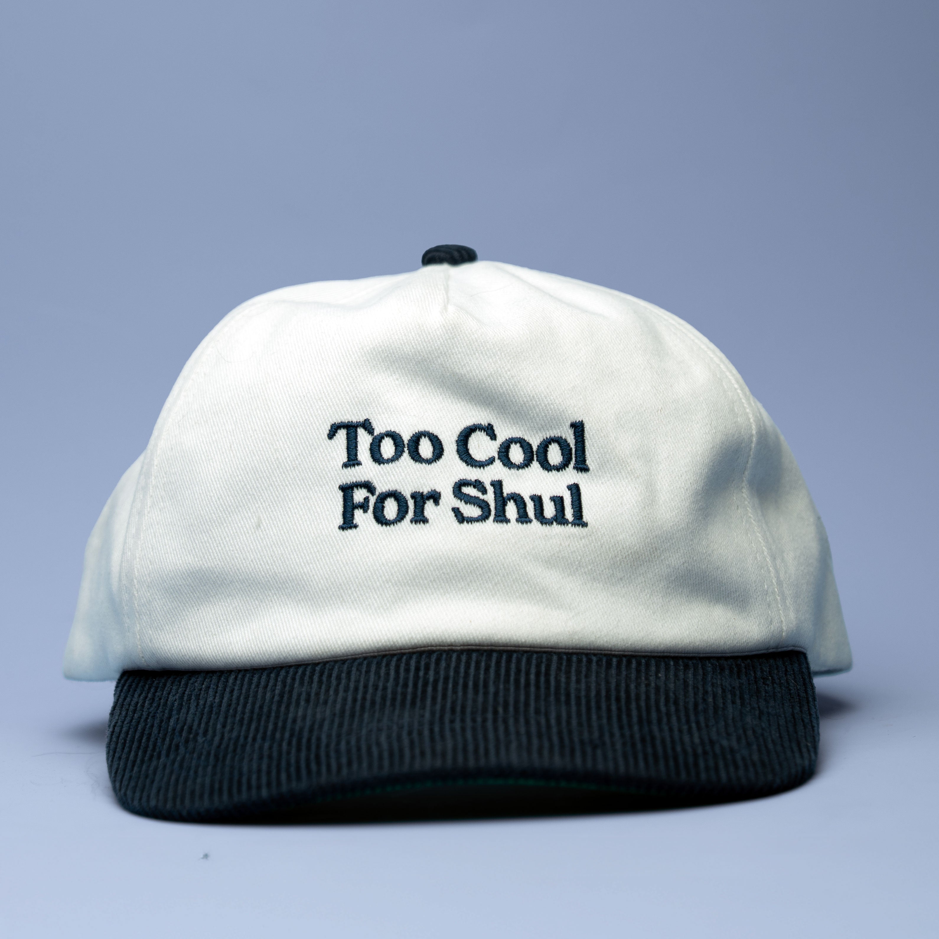 White cap with 'Too Cool For Shul' text on a light blue background
