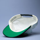 Underside of white and green hat on blue background