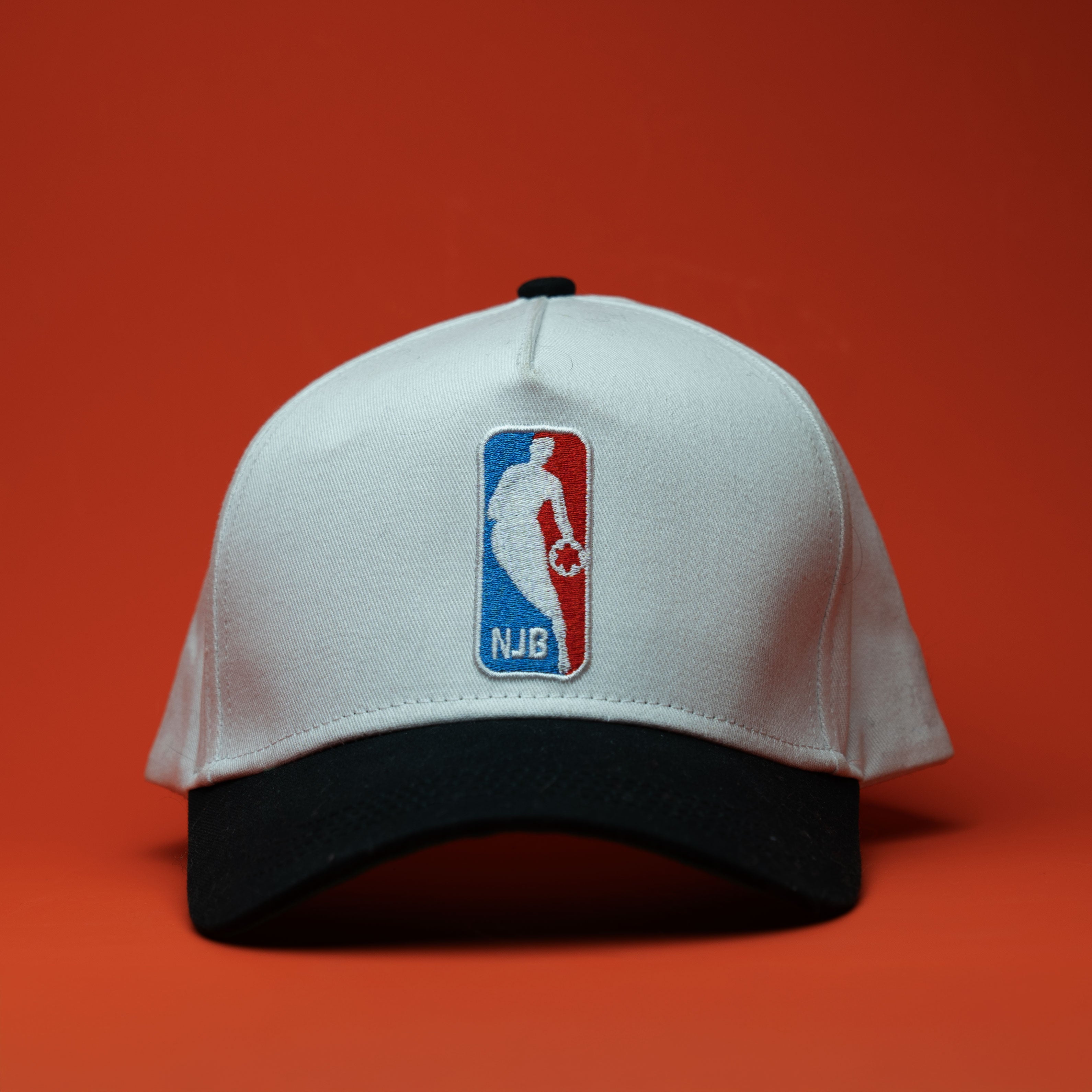 White cap with NJB logo on a red background