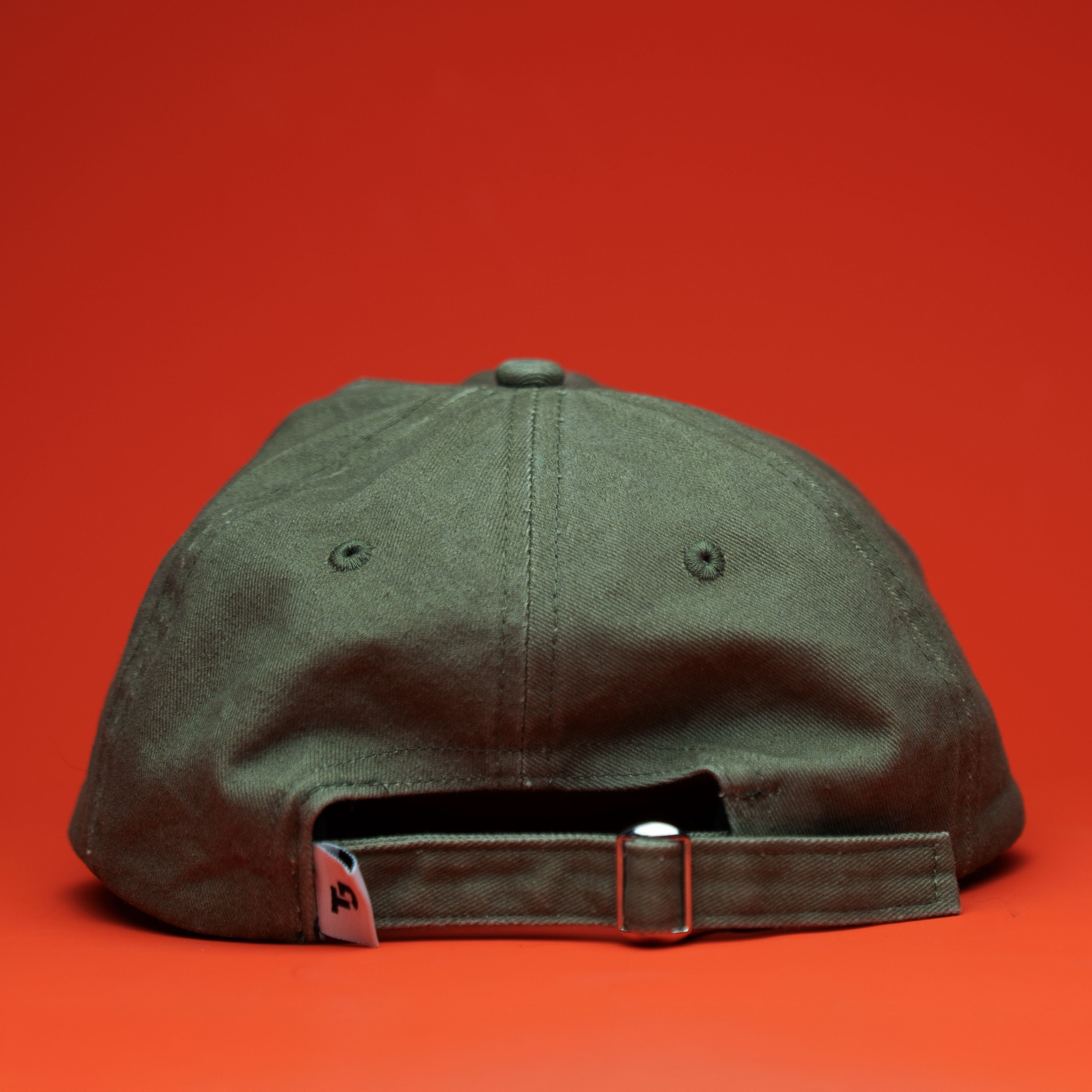Green cap with a brand logo on an red background