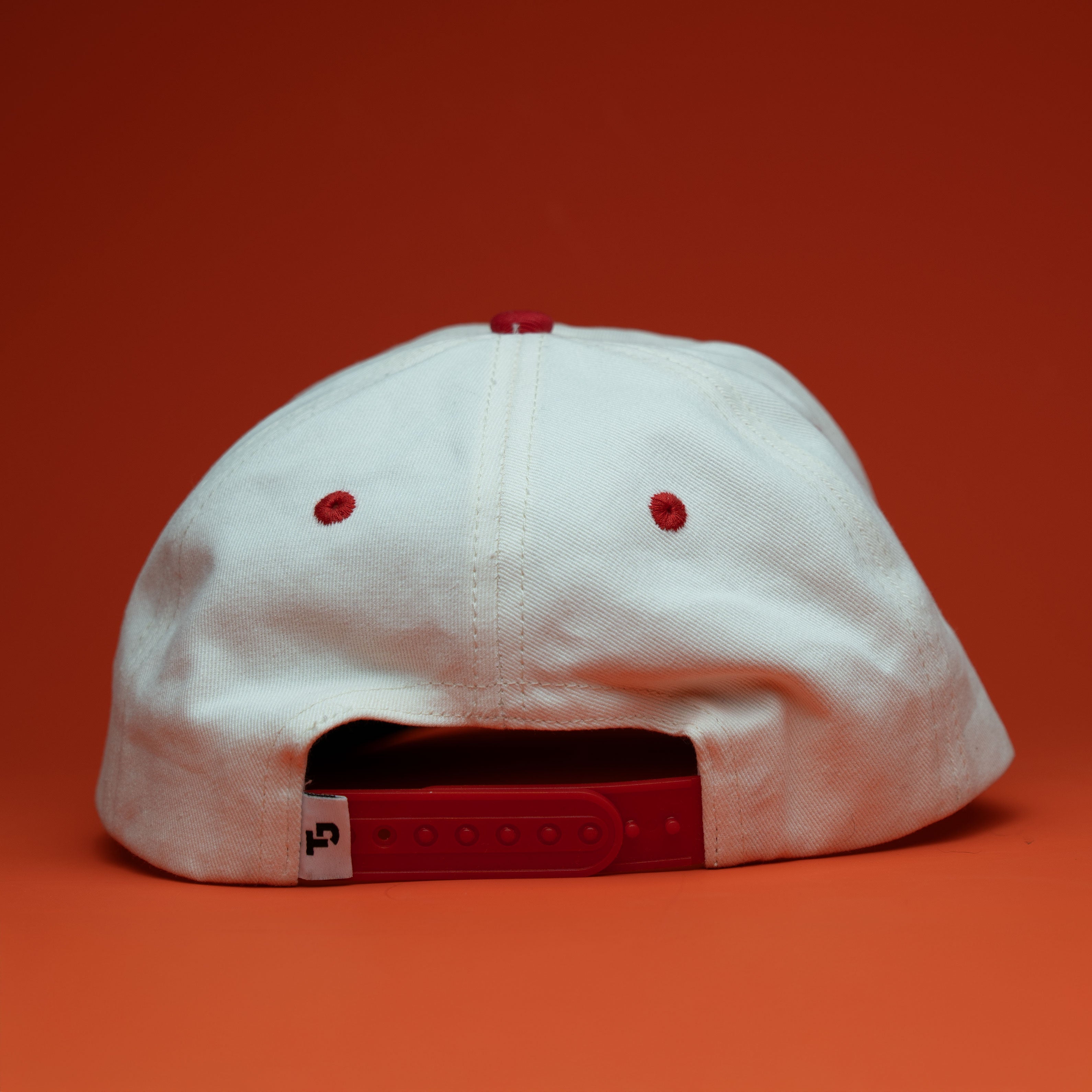 White cap with red accents on a red background