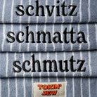 Stack of folded towels with embroidered text and a 'Tokin' Jew' brand label.