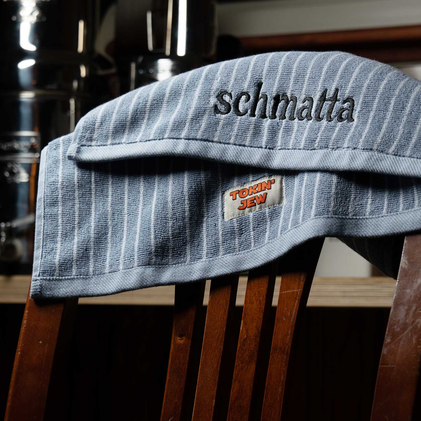 Blue towel with 'schmatta' embroidery on a wooden chair