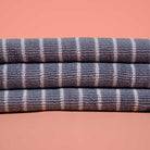 Stack of blue and white striped towels on a pink background