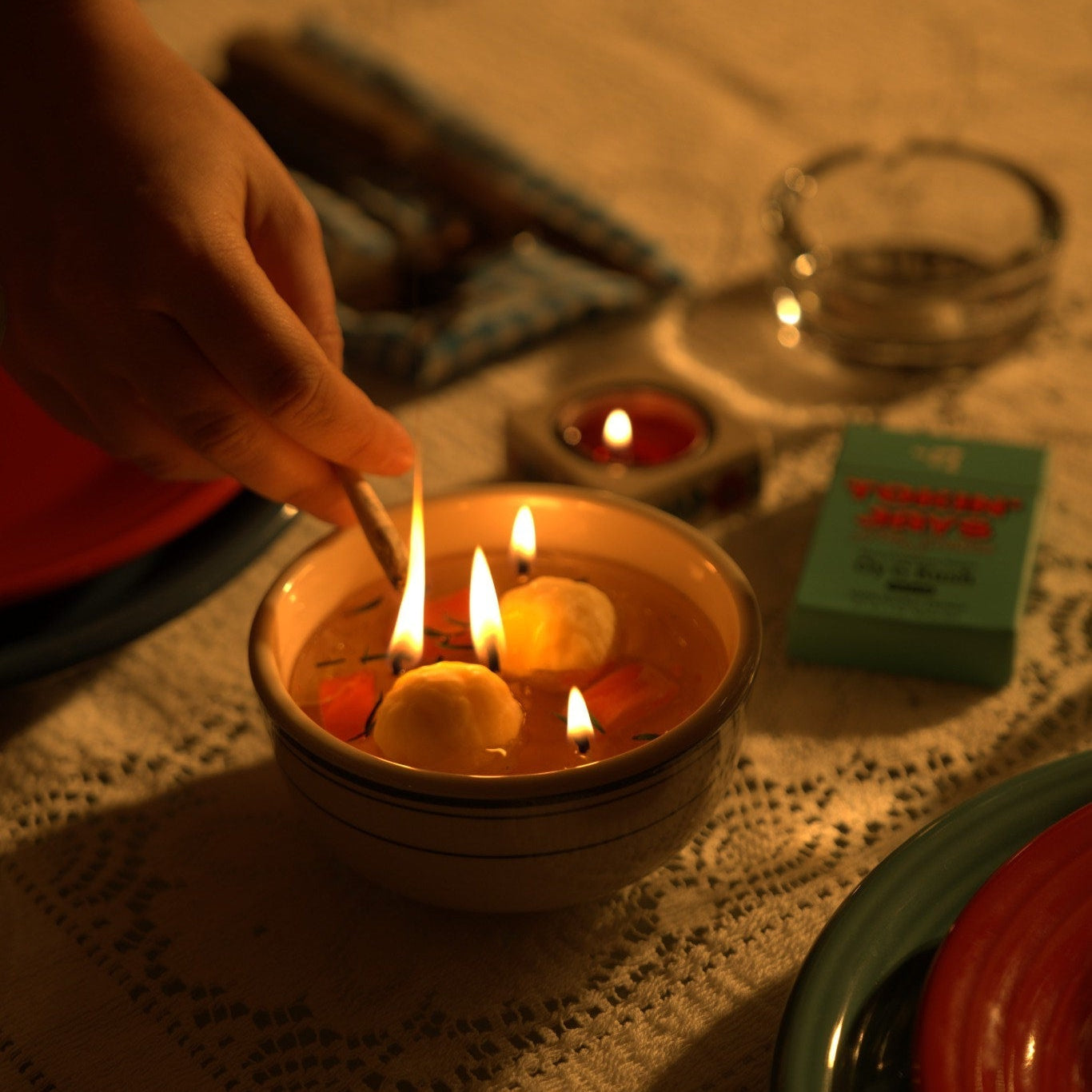 Person lighting a matzo ball soup candle with a jay.