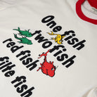 White shirt with red sleeves featuring colorful fish illustrations and text on an orange background