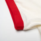 Close-up of a white shirt with a red stripe on a light background
