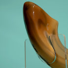 Shofar on a clear stand against a teal background