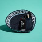 A knit kippah, dark navy, light blue, and white, shown on a solid teal background. Inside the pouch is a black lighter with white text reading 'TOKIN JEW' and a Tokin' Jay.