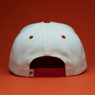White cap with red accents on an orange background